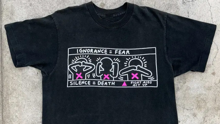 A black Keith Haring AIDS t-shirt, featuring his iconic outlined characters t-shirt and the words Ignorance = Fear, Silence = Death 