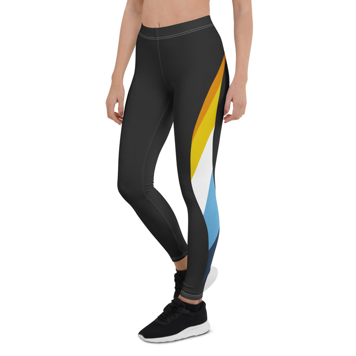 A person wears a pair of black leggings and black trainers. The leggings have the Aroace pride flag in the shape of a dynamic wave down the side.