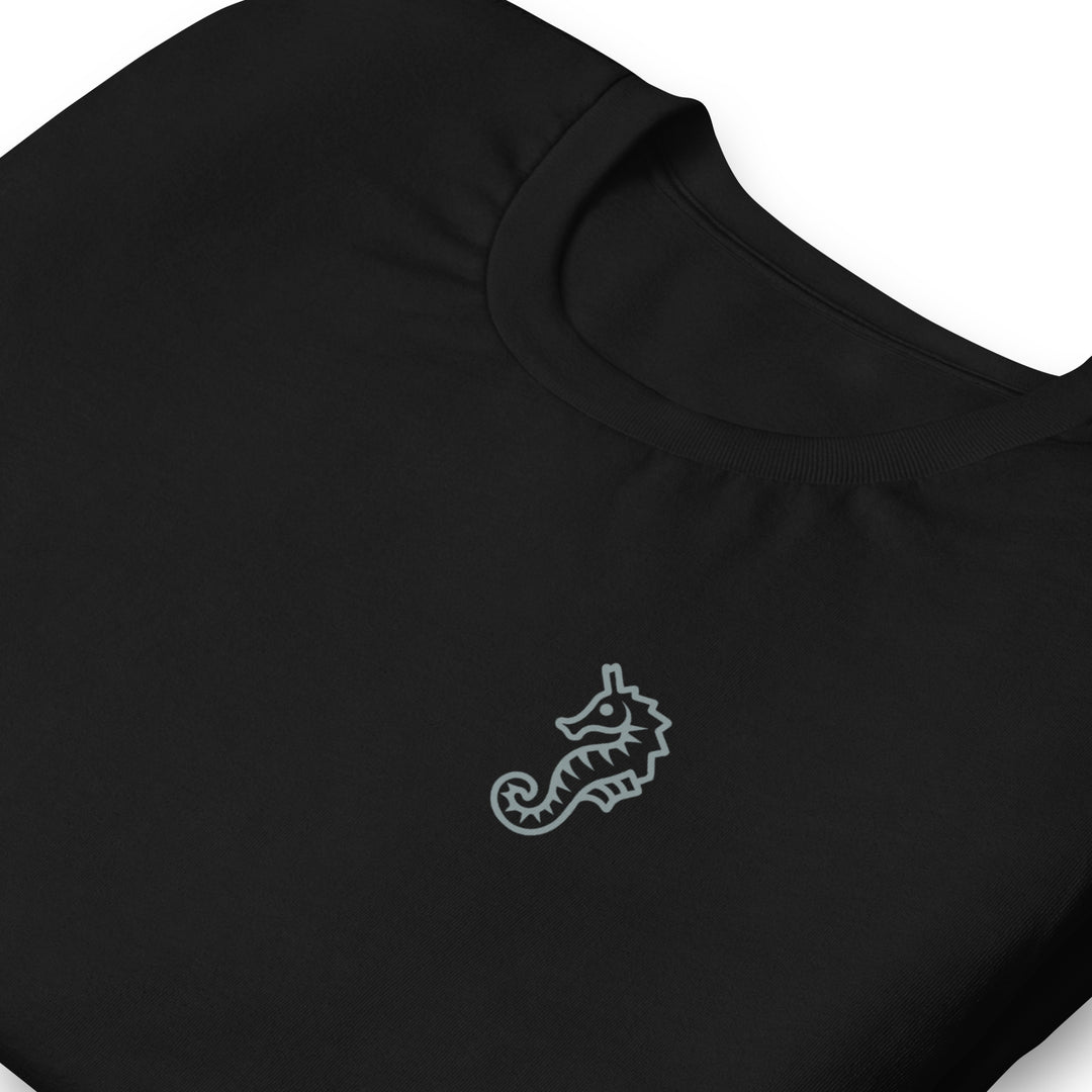 A low contrast blue grey seahorse design on a black t-shirt as a symbol of trans dads