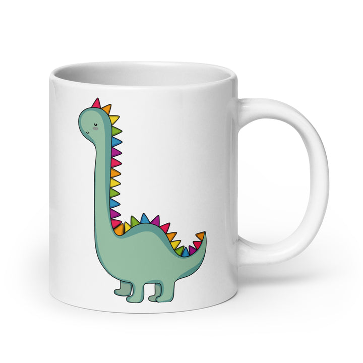 a with ceramic mug with an illustration of a cute green dinosaur with rainbow scales down it's back
