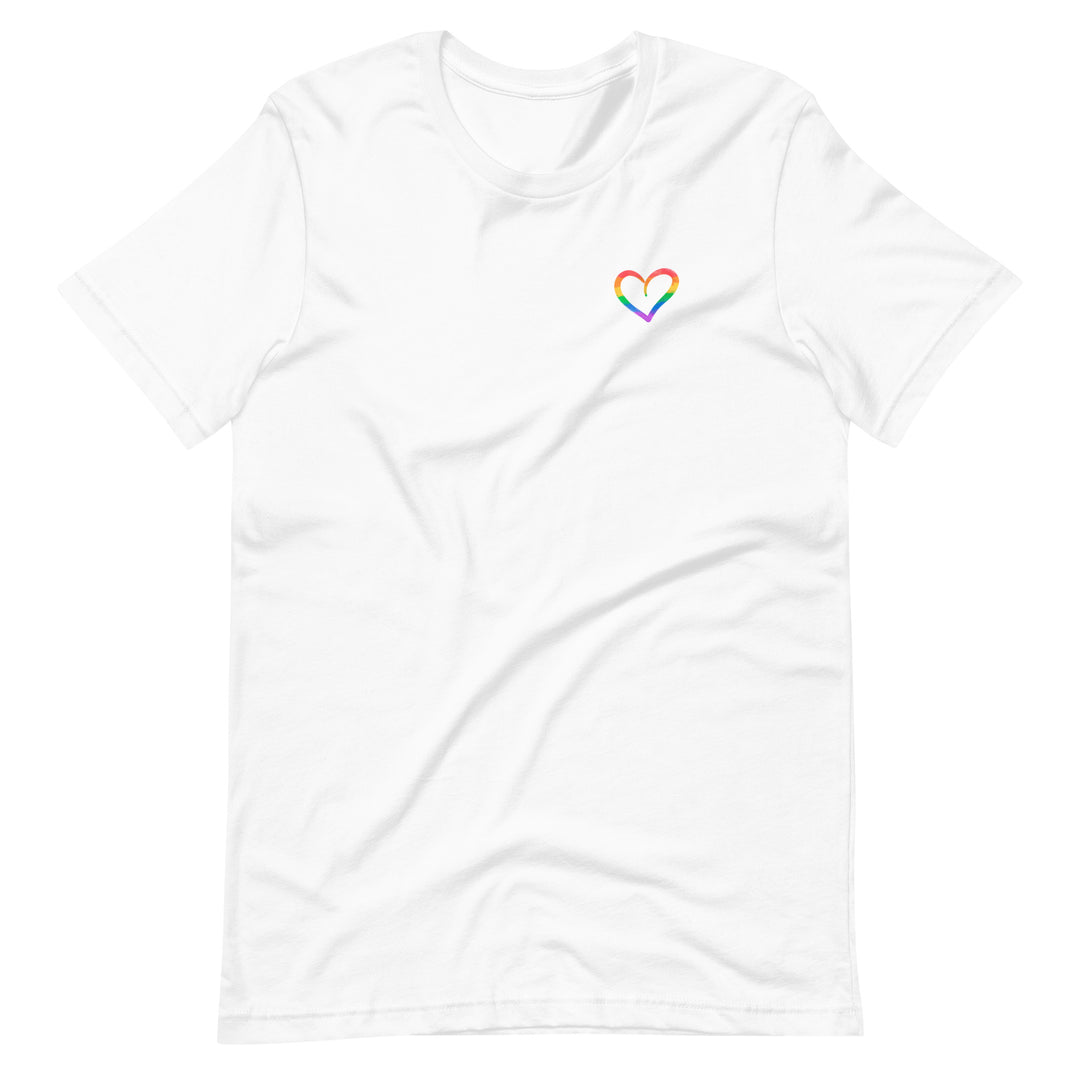 A white t-shirt on a white background, with a small hand drawn outline of a heart on the left side of the chest. Inside the lines of the heart are the stripes of a Rainbow Pride Flag.