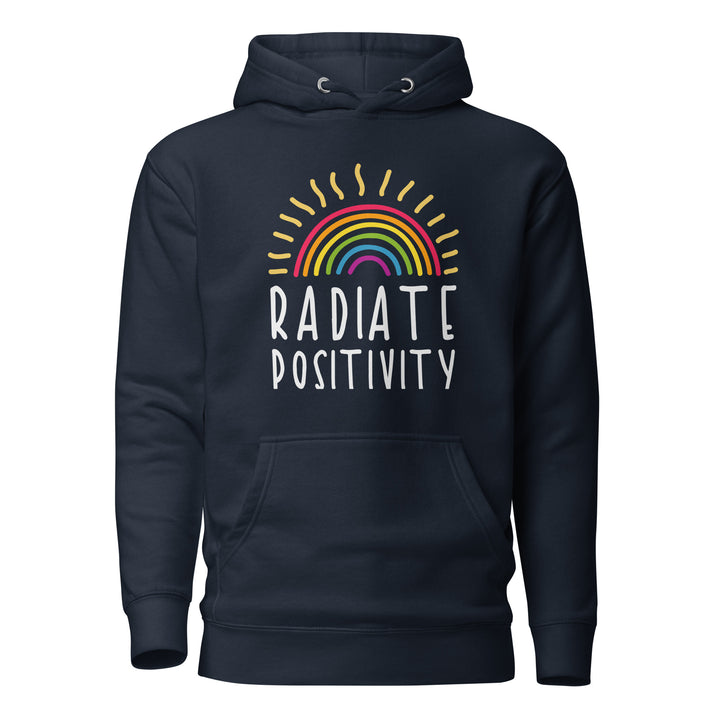 A midnight blue hoodie with the hood down, on a white background, with the words Radiate Positivity in white on the front on two lines. Above the text is a hand drawn rainbow, with warm sun rays radiating out from it. By The Rainbow Stores
