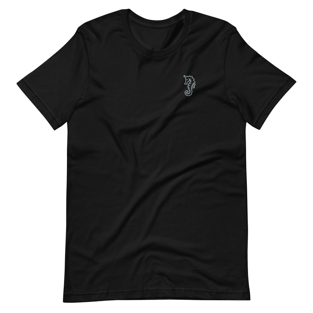 a black t-shirt on a white background, the shirt is laid flat and has a light grey trans dad seahorse design positioned on the right side of the chest as we look at the t-shirt. By The Rainbow Stores 